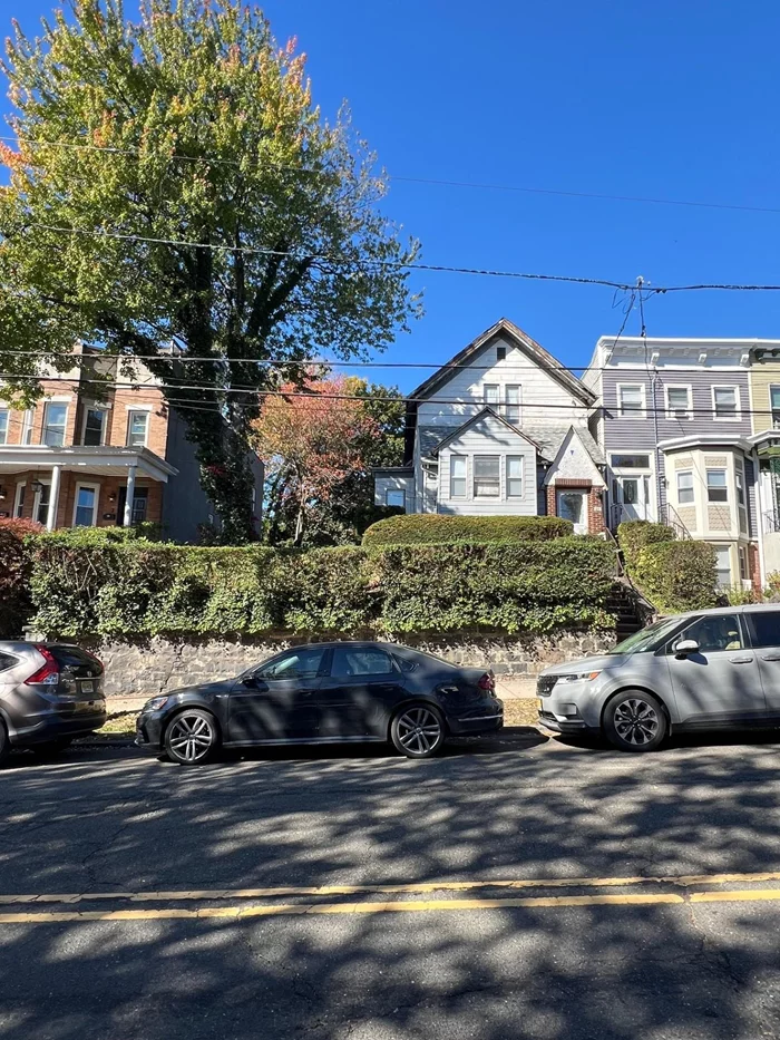 Welcome to this unique opportunity in the heart of Jersey City Heights! This one-family home sits on a generous 30x100 lot, complemented by an additional 20x100 lot, offering endless possibilities for your dream renovation or expansion. Featuring solid bones, this home is brimming with potential. With spacious rooms, high ceilings, original tin ceilings, beautiful molding, stained glass, and abundant natural light, the layout awaits your own creative imagination. Picture your ideal open-concept kitchen and cozy living spaces or restore the original character of this gracious grand dame to glory, with your own personal touch! The exterior boasts a lovely large yard, perfect for outdoor entertaining, gardening, or simply relaxing. Elevated high off street level, it affords ultimate privacy and seclusion. The two lots provide a unique space in an urban environment. Located in a vibrant family friendly neighborhood with great neighbors, you're just steps away from Washington park, local shops, and dining options. Walking distance to public transportation (Light Rail and buses), commuting to Manhattan and other areas is a breeze. Bring your vision and creativity to this promising property and turn it into the home of your dreams!