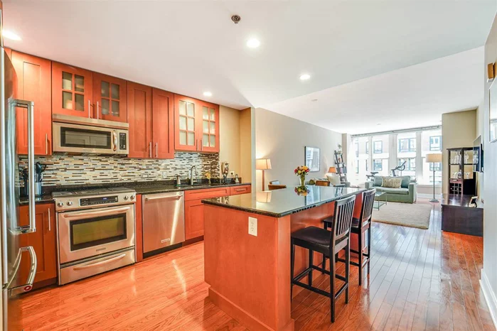WIth southern exposure and views of Maxwell Park and NYC, this supersized 1075 SqFt 1 br 1.5 baths allowing the space to live and work comfortably from home. Welcome to Maxwell Place, Hoboken's premier waterfront community. Open style kitchen features granite counters, 42 custom cabinets, SS appliances and a large island that overlooks the expansive living and dining room. Oversized master bedroom easily fits your king bed and your work desk if needed. 2 closets in br with one being a walk-in are outfitted with custom organizers. Master bath has dual sinks plus separate shower and bath. Community features 24 hr concierge, 2 gyms, 2 pools, community room with DIRECT NYC and Hudson River views and Landscaped Roof Gardens w BBq's, tv and fireplace. Commuters paradise with the ferry and bus around the corner or take the private shuttle to the path.