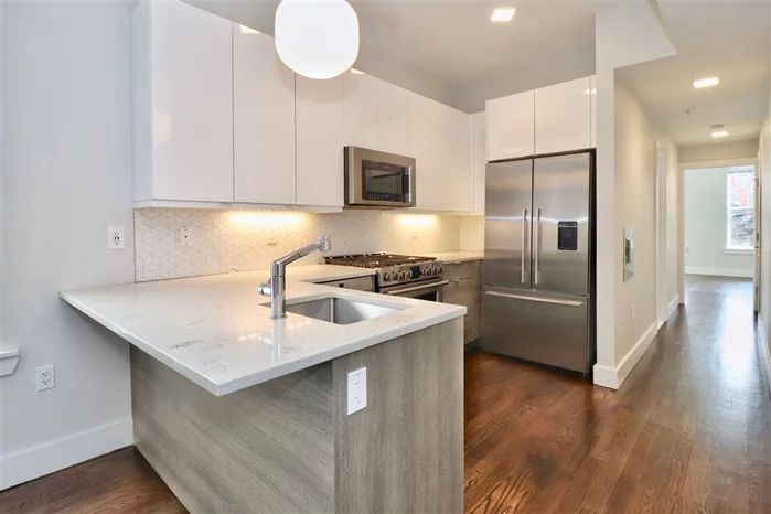 This exceptional 2 bed 1.5 bath condo is in a prime location right around the corner from the JSQ PATH station (0.2mi)!! This corner brick building was fully renovated top to bottom in 2017. This home is on the second floor (one flight up) and is bright and sunny with windows on three sides! The beautiful kitchen includes matching high-end Frigidaire Pro-Line stainless steel appliances, quartz counter-tops and custom bi-color cabinets. The spacious master bedroom provides a large double door closet. Beautiful custom vanities (from Italy & Canada) and custom floor tile in both bathrooms. Washer and dryer in unit! The building features video intercom, storage locker in basement, bike rack, shared yard with communal gas grill, as well as an additional washer and dryer. Being so close to the Journal Square Path Trains and New Jersey Transit Bus Terminal allows for quick and convenient access to NYC. Near Hudson Community College, Saint Peter's University, Schools, Shopping and Restaurants. It's also close to Hamilton Park, Newport Center, Historic Downtown and Hudson Exchange. Schedule a viewing today, in-person or virtual!