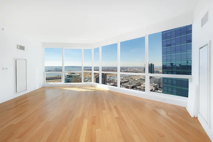 Experience luxury living in this exquisite 2BR/2BTH residence located on the upper floor of Jersey City's premier building, 77 Hudson. The architectural marvel of 77 Hudson is evident in its iconic curtain glass wall, which bathes this stunningly bright S/W corner unit in extraordinary light and offers unparalleled views of the Statue of Liberty. Revel in the sophisticated features including Italian cabinetry, Portuguese Limestone counters, and White Oak hardwood floors complemented by custom closets. The spa-like bath, adorned with Carrera marble and a spacious soaking tub, enhances the sense of opulence. This residence also grants access to resort-style living with a plethora of amenities spanning 44, 000sf, featuring a pool, park, gym, yoga studio, sauna, steam room, and more. Situated in the prime Exchange Place location, commuting to New York is effortlessly convenient with the Ferry and PATH at your doorstep. Your upscale lifestyle is further complemented by the inclusion of reserved indoor parking.