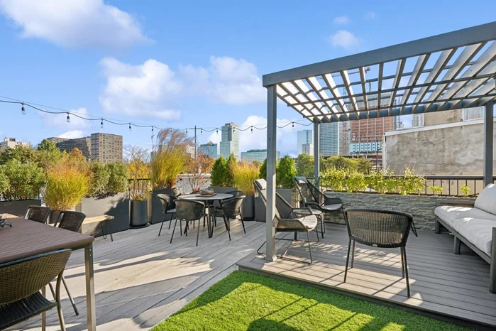 Indulge yourself in grandeur in this expansive 1905 sf duplex loft home with two private outdoor spaces including a meticulously designed rooftop deck with drip system plus a lovely terrace, nestled on a quiet tree-lined street in the heart of vibrant downtown Jersey City. Upon entering you will be wowed by dramatic vaulted ceilings with a wall of south facing windows flooded with abundant natural light, and the open concept layout flowing seamlessly from separate dining area to kitchen to spacious living room. And you will no doubt appreciate the extra large contemporary kitchen, well-appointed with rich 42 wood cabinetry, glass back splash, stainless steel appliances including a 6 burner stove, granite counter tops and breakfast bar with elegant pendant lighting. Perfect for entertaining family and friends or just relaxing in your idyllic urban retreat. Head down the hall to a splendid guest bath with soaking tub plus two sizeable bedrooms, both with sliding glass doors leading to a private 225 sf terrace, and the tranquil primary with large custom walk-in closet and tasteful marble ensuite bath with dual sinks, over-sized shower and heated floors. A laundry room with side-by-side washer/dryer plus additional storage round out this perfectly designed first floor. Make your way to the second level and enjoy the architectural detail below from another generous space that can be used as a den, home office, play area or third bedroom, complete with huge walk-in closet, stylish windowed marble bath with dual sinks plus separate soaking tub and glass enclosed shower, and the convenience of a built-in wine fridge with wood cabinetry and granite top. And for the epitome of urban luxury living just step out to your beautiful 420 sf roof deck where you can savor al fresco dining under your pergola, enjoy a bit of seasonal gardening or just unwind in your serene oasis after a busy day.Complete with beautiful hardwood flooring, recessed lighting, crown molding, ceiling fans, central air and heat, and abundant storage throughout plus a rarely available private 14' x 18' / 252 sf storage room this delightful abode can be yours to call home. Become part of the Harsimus Cove community and enjoy downtown Jersey City's many cultural activities, Hamilton Park, superb dining, nightlife and shopping, and with easy access to the PATH train into Manhattan.