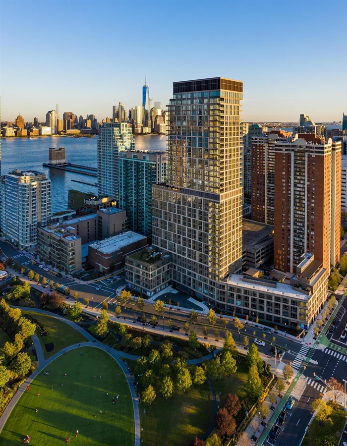 Residence 1804 is a two-bedroom/two-baths showcasing views of the serene and acclaimed Newport Green Park and partial views of the Manhattan skyline. This view is beautifully framed by expansive windows that bathe the interior in abundant natural light. This residence impressively presents an open and spacious floor plan, thoughtfully equipped with generous storage solutions. Notably, the master bedroom is both spacious and practical, boasting two built-in closets for your convenience. Moreover, you'll discover a linen closet in master bath and a pantry seamlessly integrated into the chic Chef's kitchen. This culinary haven features a gallery island, perfect for both casual dining and entertaining, adding an element of sophistication to the living space. Situated between two PATH terminals, amidst the lush greenery of a thriving park along the Hudson River waterfront in the vibrant Newport neighborhood of Jersey City, you'll discover 75 Park Lanea collection of 358 custom-designed residences. These homes range from spacious studios to generously sized three-bedroom units, as well as state-of-the-art luxury penthouses adorned with mid-century artisanal touches. The property also boasts a welcoming porte cochere, making 75 Park Lane a warm and stylish addition to Jersey City's waterfront. Soaring 37 stories high, this skyward sanctuary offers residents a tranquil retreat while enjoying breathtaking sunrise views against a backdrop of panoramic vistas. These intelligently crafted luxury condos are enveloped in natural light, fresh air, lush green surroundings, and stunning vistas of the Hudson River and the Manhattan skyline. Each residence features an elegant chef's kitchen, perfect for both casual dining and entertaining, complete with an Integral Bosch appliance package, undermount stainless steel sink, Madreperola Quartzite waterfall island and countertops, and millwork finished with satin nickel trim. The master bathrooms are equally well-considered, showcasing clean lines, impeccable craftsmanship, Stellar White marble floors and walls, frameless all-glass showers, and custom vanities. Additional impressive features of 75 Park Lane include in-unit washer/dryers, adjustable central A/C, and a suite of smart home features, including keyless entry. Whether you're focused on work or leisure, 75 Park Lane's amenities create a homeowner's paradise. An indoor heated lap pool and adjoining fitness center, complete with a yoga room and a teak-lined spa with steam rooms, cater to your wellness needs. The property also offers a wine tasting lounge with a private dining room, adjacent to a co-working space, a private conference room, and a multimedia lounge for movie nights or karaoke sessions. Golf enthusiasts will adore the sixth-floor putting green, which offers sweeping views of Midtown Manhattan and Newport Green Park. And for moments of relaxation or hosting large gatherings with friends, the sky lounge, a landscaped rooftop lounge and dining area equipped with a full prep kitchen, provides a serene escape.