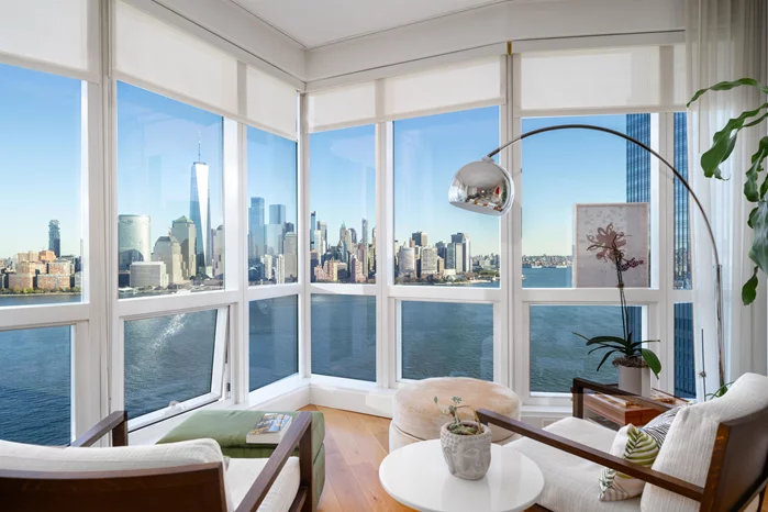 A rare opportunity to own a truly exceptional two-bedroom plus den residence in Jersey City's most iconic building, 77 Hudson. Perched high above the Hudson River, this exquisite home offers 1, 558 square feet of luxurious living, boasting sweeping, unobstructed panoramic views of the NYC skyline and Hudson River through floor-to-ceiling curtain glass walls that flood the space with extraordinary natural light. Larger than most three-bedroom units in the building, this sophisticated residence features a spacious, open-concept living and dining area, oversized bedrooms, a spa-inspired primary bathroom, and a versatile den perfect as a home office or guest room. Custom upgrades elevate the home, including designer flooring, a built-in desk, a Murphy bed, and integrated sound systems, blending modern convenience with timeless elegance. The ultra-sleek European kitchen and bathrooms further showcase unparalleled craftsmanship and style. Residents of 77 Hudson enjoy access to unparalleled resort-style amenities, including a state-of-the-art fitness center, outdoor pool, jacuzzi, yoga and Pilates studio, steam and sauna rooms, massage suites, a private screening room, and more. Located in the prestigious Exchange Place neighborhood, this home offers effortless commuting options with the PATH, ferry, and Light Rail just steps away. One coveted parking space is included, completing this extraordinary offering.