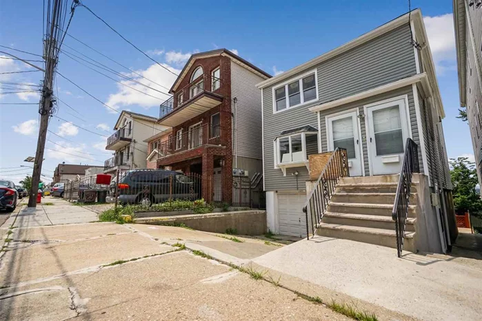 Walk into this great 2 family house in the Western Slope of Jersey City Heights! This house offers 2 functionally laid out units. First floor unit features a large living area with a beautiful bay window overlooking the street, an eat in kitchen with plenty of space for dining table, a renovated bathroom with new tiling and fixtures, and three bedrooms with ample closet space. Second floor unit is identical in surface and lay-out to the unit below, and same upgrades. There is a bonus in-law apartment suite on the ground floor, that leads to a deck, patio and back yard. This house has a one car garage with automatic garage door and a driveway. Siding and windows are brand new. Great neighborhood, close to schools, shops and commuters transportation into the city. Low taxes, a MUST see