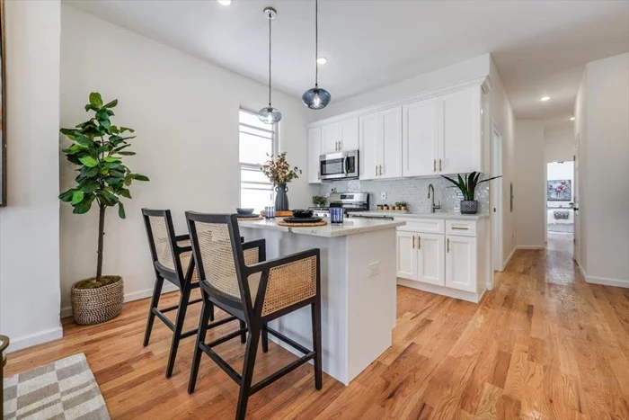 Nestled in the charming Bergen Lafayette neighborhood of Jersey City, this freshly renovated 2-family is move-in ready and primed for passive income. A beautiful blend of classic charm and modern convenience come together in the 3-story, 6 bedroom, 5 bath property including the oversized backyard. In each unit, light floods the inside through a big bay window showcasing the open floor plan and eat-in kitchen, while original hardwood floors and classic wood trim add timeless character. The kitchen features creamy quartz counters, glass tile backsplash, white shaker cabinets, stainless appliances, and brass fittings.  Unit 1 spans two stories, offering 3 bedrooms, 3 baths, and a full-floor finished bonus room with additional storage. Unit 2 also includes 3 bedrooms, 2 baths, and completes this versatile property. Owners enjoy the oversized backyard, ideal for outdoor gatherings and relaxation. Inside, large bedrooms feature excellent closet space, while bathrooms host stylish vanities, bathtub and shower, plus modern smart mirrors. The brand new stacking washer and dryer bring ultimate convenience.  Settled in Bergen Lafayette, residents enjoy boutique shops and cafs, as well as nearby Lincoln Park with running trails, sports facilities, farmers markets, and golf course. Commuting is a breeze with access to the Lightrail and Journal Square PATH, making this property an ideal investment in both comfort and convenience.