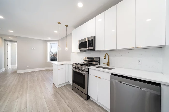 **NO FEE** This updated 2 bedroom and 2 bath home is located in the heart of Jersey City Heights. The neutral palette and beautifully stained original hardwood floors are complemented by the abundant natural light. The split bedroom layout provides optimal privacy and flexibility. The open floorplan living and kitchen area features charcoal-gray cabinets, white quartz counters, classic subway tile backsplash, matching stainless sink and appliances plus nickel fixtures. The front bedroom boasts oversized bay windows and huge side-by-side closets, plus full bath adjacent. Through to the back, tenants enjoy convenient in-unit washer and dryer, plus additional bath and bedroom (will fit a full size bed, will tightly fit a queen size). The building exterior has been recently updated with new siding and fresh trim. This home is located less than 1 block from Leonard Gordon Conservancy Park and is a quick walking distance to urban thoroughfares Summit and Central Ave plus beautiful Pershing Field Park and next door Reservoir. Jersey City Heights offers a vibrant community, great restaurants and essential shops, excellent schools, and easy NYC access. (some photos are virtually staged). Dogs up to 35 lbs are allowed. Available ASAP