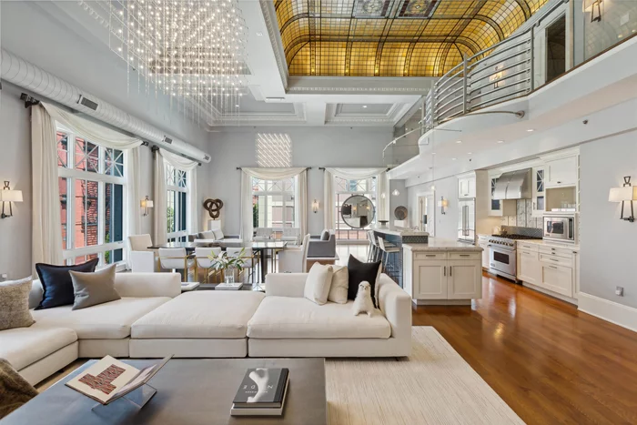 Stunning, one-of-a-kind corner loft at the Historic Jefferson Trust Bank building. Built in 1909 and placed on the National Register of Historic Places in 1986, this truly unique space has soaring 21 foot ceilings, 3180 SF of living space, 2 bedrooms plus den, 2.5 bathrooms, private keyed elevator access into the home and garage parking for one car. Designed for entertaining, the five 9.5 foot high windows with northern and western exposures saturate the great room with natural light. The original egg and dart plaster moldings and spectacular 400 square foot stained glass backlit skylight are significant examples of the historic architecture of the building and compliment the loft's scale and opulence. Open chef's kitchen features Viking appliances, Carrara marble countertops and large island with breakfast bar. Both bedrooms have en suite bathrooms complimented by duel sinks, soaking tubs and showers. Second floor den provides the perfect home office or nursery. Half bath, laundry room, dark stained wide-plank solid oak hardwood floors, motorized window treatments, smart-lighting system, fire place and duel HVAC system round out this incredible home. Garage parking plus proximity to PATH, ferry, light rail and busses make commuting a breeze. Option to be rented furnished.