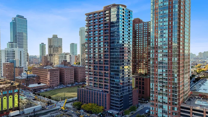 Experience refined living in this spacious 2-bedroom, 2-bathroom condo for lease on the Jersey City waterfront. This stunning 1, 400 sq. ft. corner unit boasts floor-to-ceiling windows with 180-degree views, including the NYC skyline from your private balcony. The open-concept layout is bathed in natural light, featuring a gourmet kitchen with stainless steel appliances, generous counter space, and a dining area. Enjoy plenty of closet space throughout, including a walk-in closet in the primary suite, which also offers an en-suite bathroom with a dual vanity, deep soaking tub, and standing shower. Additional conveniences include an in-unit washer/dryer, deeded garage parking w. direct access to lobby, and utilities (except electric, cable, and WiFi). Building amenities include a modern gym, NYC-view lounge, children's playroom, a BBQ-equipped outdoor lounge and on-site superintendent. Ideally located walking distance to near top-rated schools, PATH, Harborside Ferry, Light Rail, Newport Centre Mall, Grove Street Pedestrian Plaza, and the new Whole Foodsthis home places the best of Jersey City right at your doorstep. Parking available for additional $250 & pets allowed on a case by case basis.