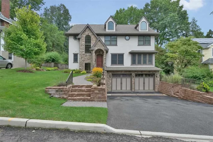 A grand entryway with cathedral ceilings greets you as you step into this 5-bedroom, 3.5 bath, stone-and stucco Colonial home built in 2009 in Tenafly. The ground level has hardwood flooring and surround sound throughout with a dining room, front room, grand room, kitchen and sunroom. Stainless steel appliances, two ovens, granite counter-tops and 3-seat center island create a beautiful kitchen while the Travertine tiled bathroom, gas fireplace and rear deck complete the fine detailing downstairs.