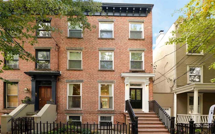 Magnificently restored 20' wide, semi-attached brick row house, with 2, 400sq ft of living space organized over four floors. This home, a legal three family acting as a single family, is in the historic downtown area of Jersey City and is located one block from Hamilton Park. Custom designed kitchen with Bertazzoni 4 burner stove, quartz counters, stainless steel appliances and pantry with floating shelves on the parlor level. Step out onto your private Trex deck and large landscaped yard from your kitchen. Top floor has vaulted ceilings with exposed beams and exposed brick. A beautiful garden level adds a wonderful space for your family room, and a large laundry room. Hardwood whitewashed 7 wide white oak floors throughout the home. Radiant heated marble tile floors are in three full marble baths for added comfort. New windows throughout the home: Marvin windows on the front, and sound insulated floor to ceiling picture windows on the parlor level living room. Great natural light shines all day, and in the evening all rooms are illuminated by recessed lighting. Original brick hearth in living room with crown molding, 7 floor base molding and solid wood Shaker doors with crystal doorknobs throughout the home. French vestibule door, and five genuine crystal chandeliers illuminate the home. Good storage added with large walk-in custom organized closets with built-in cabinetry. Mitsubishi 5-zone ductless energy efficient heating/AC system. Only one block from Hamilton Park, close proximity to two PATH Stations to NYC, restaurants and shops. Meticulous attention to detail for the discerning buyer. Make this your dream home!