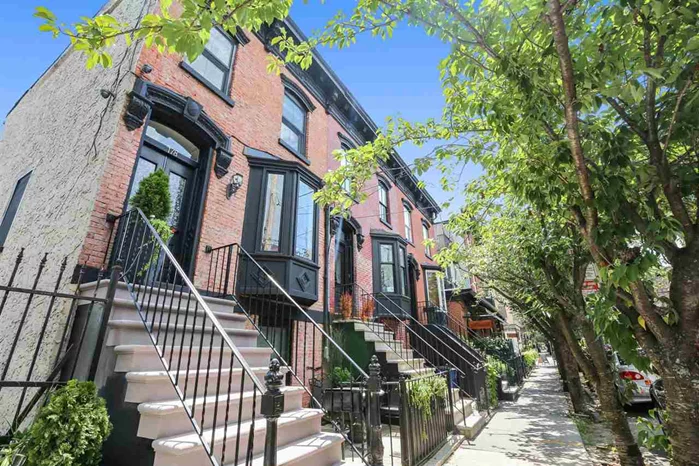 Gorgeous Hamilton Park corner brownstone in the historic downtown Jersey City section. Walk right into your bright double entry glass doors with an open living room/dining room concept. Beautiful sun drenched bay window, decorative fireplace with exposed brick. Chef's kitchen with SS appliances, gas stove with vented hood and gorgeous granite countertops. Cozy covered deck is perfect for entertaining and summer BBQ's. Top floor master bedroom suite with exposed brick, soaring high ceilings with skylights. Huge walk in closet space, spacious bathroom and hardwood floors throughout! Private entrance with walk out basement (with possible 3rd bedroom) leading to your front patio. Renovated bathroom, custom cabinets and tankless hot water heater. Smart home ready with a full security system. Perfect location for commuters, minutes to shopping, restaurants, parking, buses, park and Path trains to NYC. This home has been completely renovated and is a rare find. Make it your home today!