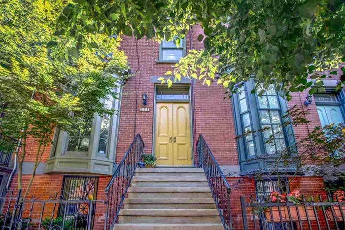 Welcome home to this lovely townhouse on a quiet, tree-lined street in the heart of Jersey City's Harsimus Cove historic district. This three story, single-family 1870's home has been thoughtfully renovated to preserve the original, heirloom qualities that make it such a rare find. Accessed through the front French doors, the parlor level retains its original large bay window, plaster walls and picture-rail crown moldings, as well as its wood-burning fireplace with original marble mantle. The dining room is illuminated by a cut-glass chandelier, and the home's antique pumpkin pine floors glow with a warm patina. The parlor level's two main rooms have retained their original 19th century dimensions, while an updated extension at the rear of the house currently serves as a cozy, light-flooded office overlooking the garden below. The parlor floor also has a full bath with porcelain fixtures and tile shower. Downstairs, the garden level is perfect for entertaining, and has a separate entrance from the street. Here you will find a large updated kitchen, with stainless-steel appliances, including a Bosch dishwasher and 5-burner DCS gas range. The kitchen opens through French doors to a sunny, private garden with English ivy and flowering roses. The garden level's beadboard ceiling and original coal stove serve as a reminder of the home's historic past. Wood cabinetry with glass handles provide ample storage, while concealing the convenient washer and dryer. On the top floor, you will find two spacious bedrooms with large closets, and a full bath with period fixtures, including a cast iron bathtub with shower. Enjoy experiencing what home means in this fine example of 19th century living, updated with all the amenities of today. Make it yours!
