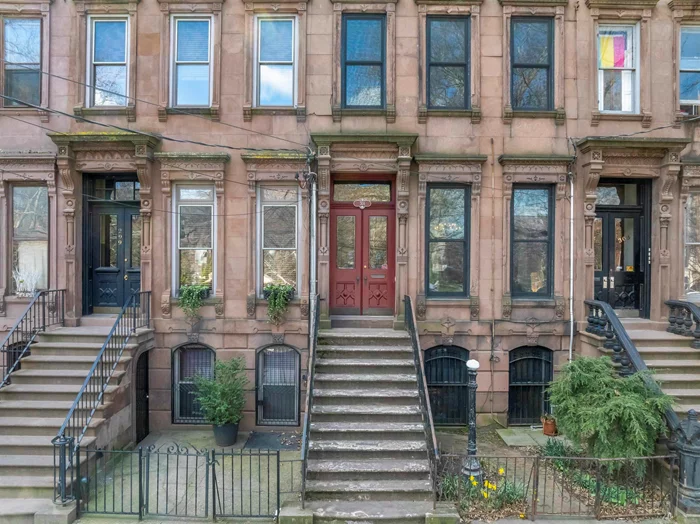 Circa 1875, this classic Italianate style brownstone, spanning 18 feet wide, faces the picturesque Historic Van Vorst Park, boasting a deep 100-foot lot. Upon entry, the double doors lead to a parlor level through an inviting vestibule featuring a mosaic tiled floor with stained glass door panels and transom, opening into a spacious foyer, a large living/dining area, and a well-equipped EIK with top-of-the-line Sub-Zero, Miele & Wolf stainless appliances and 9' soapstone island. Enjoy access to the south-facing 13'x19' deck and garden from the kitchen bay and spiral staircase. The upper two floors showcase a primary bedroom with a wood-burning fireplace nestled in a sun-drenched bay window, complemented by a dressing area with original cabinetry and a marble top basin and three additional bedrooms, with one currently being used as a spectacular library/family room, an office/nursery, laundry, with new w/d, and two fully remodeled, high-end modern baths. The garden level, complete with a full bath, private entrance, and direct yard access, currently serves as a versatile home office and guest suite. This floor offers potential for long or short-term rental opportunities. Noteworthy features include 11' ceilings, seven etched slate mantels, plaster moldings, original shutters and cornices, intricate parquet floors with mahogany inlay and etched glass pocket doors. The property also boasts a spacious garden, full basement, central air on the lower three floors, custom O'Lampia lighting and newer Marvin windows and doors throughout, adding to its allure and charm.