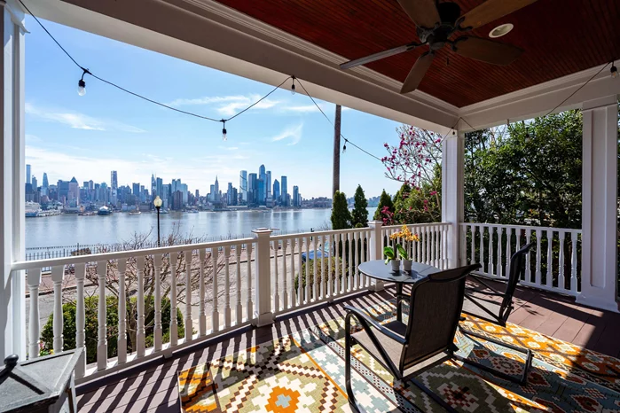 Rare opportunity to own one of only five homes on historic Hamilton Avenue in Weehawken, site of the famous Hamilton-Burr duel that inspired Hamilton. With full direct views of the NYC skyline and the Hudson River in King's Bluff, along with a private garage, this grand Victorian home has been magnificently restored and lovingly renovated, and is an impressive, majestic home that is ideal for entertaining on a grand scale. Enjoy the all-encompassing view from the main porch or one of the 3 balconies off the bedroom suites. The private garage accommodates 3 cars (tandem), two additional spots outside, and ample free street parking. Inside, the striking entry hall and dramatic staircase beckons, with imported Ukrainian inlaid wood flooring, leading to the magnificent living room with stunning views, as well as the immense family room with fireplace, and formal dining room framed by NYC views. The custom chef's eat-in kitchen has a separate dining area that seats 8, with expansive granite counters / breakfast bar for additional seating, custom Parsons wood cabinets with storage galore, 48 Viking Professional series stove with hood, Sub Zero refrigerator, Bosch dishwasher, and convenient powder room. Just beyond is a bucolic deck and yard. The two upper levels feature 3+ bedrooms (6+ total), including 4 en-suite bathrooms, and 4 of these rooms feature direct NYC views. The massive primary suite includes an oversized bedroom, spacious sitting room, walk-in closet and huge primary bath with separate, serene soaking tub, glass shower, WC, and dramatic vanities. Every bathroom has been thoughtfully renovated with stylish accents such as terracotta tile floors, onyx counters and floors, glass tile showers and unique furniture vanities. Soaring ceilings throughout - first floor is 11', 10' on the second and 9' on the third floor. Wood details include Ukrainian wood inlaid floors, family room fireplace mantel, and two sets of oak/glass pocket doors, original molding, tiger wood paneling and spindles plus coffered ceiling. Lower level features an additional bedroom, full bathroom, laundry, 2nd refrigerator, gym/office/playroom, storage, and attached garage. Two zone central air and heat, and Marvin windows and doors. A commuters' dream, just moments to NYC bus, ferry, light rail, or 5 minute drive to the Lincoln Tunnel. Truly a unique opportunity to own this luxurious and stunning home, with the ever-changing NYC skyline and river views.