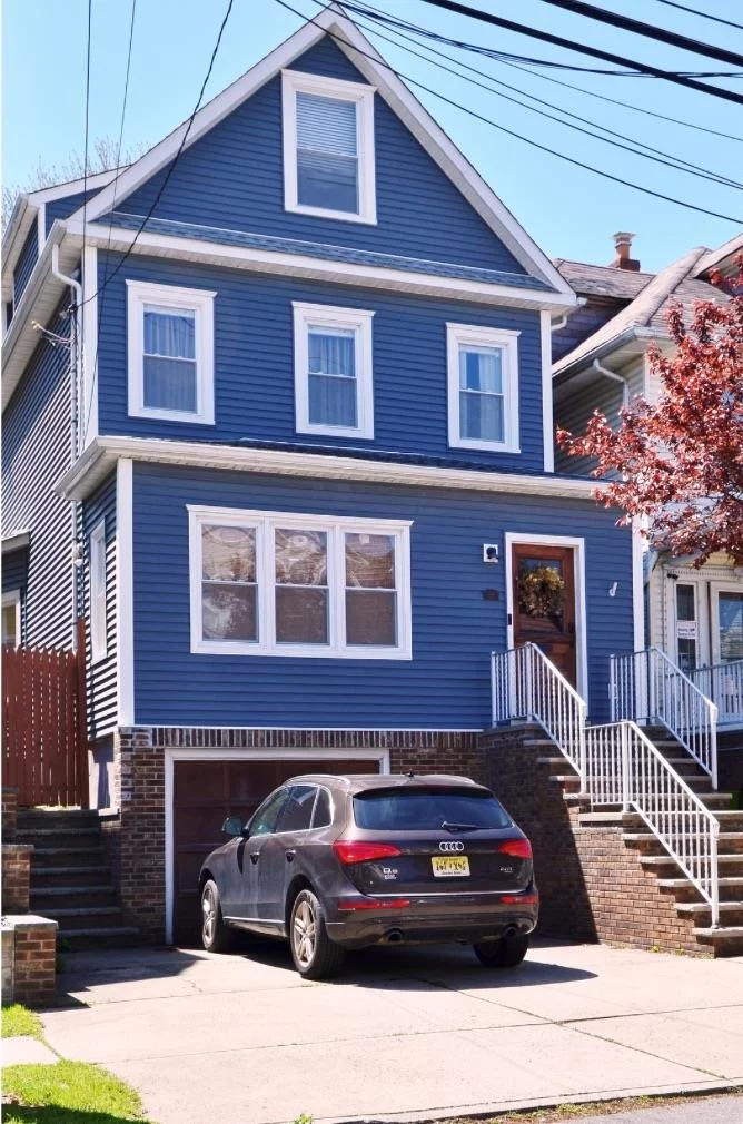 Presenting an immaculate abode! This single-family home, which sits on a beautiful block in Bayonne, was completely renovated in 2015. While maintaining its original character and features that add the modernity you will delight in.  This property offers an exquisite blend of modern amenities and serene living, featuring a 2000 sq ft interior floor plan composed of 4 bedrooms and 3.5 baths and a landscaped private yard with a children's playground, a stone patio, and outdoor kitchen.  This truly exceptional home is poised elegantly on a 30x100 lot, 2-car wide parking driveway and garage for 3rd indoor parking spot. Inside the doorway lies a mudroom - an organized drop zone for coats, shoes, and other necessities. Further enhancing the allure of this property are the tranquil bedrooms on the second floor, a full bath, and the accompanying redesigned primary suite lavished with its remarkable en suite bath with towering ceilings, stained glass windows, central air, and heating, a standing shower, and a walk-in closet. The home also offers a washer and dryer on the second floor adjacent to bedrooms.  The finished loft serves as a separate suite within the home, or a playroom, teenager's sanctuary, additional living area, office, or guest suite with its own beautiful full bath, mini kitchen area, skylight, and spectacular Freedom Tower views!  This property is strategically positioned within three blocks of the Light Rail, is in proximity to all of Bayonne's great retail shopping, including Costco, Walmart, Lowe's, Stop & Shop, TJ Maxx & Home Goods and more! Future ferry to NYC, scheduled to commence soon!