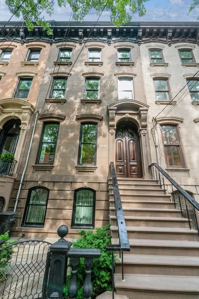 Nestled in the heart of Downtown Jersey City's Van Vorst neighborhood and just blocks from Van Vorst Park, this charming 4-story single-family home offers unparalleled convenience and allure to its new residents. Situated on a picturesque, tree-lined block on Varick Street, surrounded by rows of historic brownstones, it blends original 1860s architectural details with 21st century flair and comfort. Step inside to discover a spacious layout with endless possibilities. The garden level welcomes you with an expansive entertainment area featuring a bespoke grain matched oak wet bar with illuminated drink shelves, wood burning fireplace, Sub-Zero fridge freezer with ice maker and Sub-Zero dual zone wine cooler. The guest bath is so inviting with Brazilian inspired hand printed wallpaper, and Duravit floating toilet & vanity. A custom NanaWall folding door system leads to an outdoor oasis. Your garden features a travertine patio, ip fencing, remote controlled cassette style awning, infrared heater, lighting and bamboo planters. Ascend to the parlor level, dedicated to all of your dining needs with your formal dining room and dream kitchen flooded with natural light. The kitchen is adorned with imported cabinets from Italy, a Wolf Gas Range with infrared grill, Sub-Zero built in Refrigerator/Freezer and dual zone wine cooler. Original arched double doors and marble fireplace add charm to this modern space. Enjoy outdoor relaxation as you dine on the ip and glass deck, which can be accessed off this level. The top two floors offer two bedrooms each, with the top floor having an additional room which can be a 5th bedroom or a home office, gym or nursery. The third floor bathroom features travertine tile, a mirrored wall cabinet, Kohler shower with frameless door and radiant heat. The top floor bathroom has similar attributes, and additionally features a stacked Kenmore Elite washer/dryer. Additional highlights include new plumbing, new electric, new 200amp service, new kitchen, 3 new bathrooms, all floors refinished or replaced, heated floors in the upper level bathrooms and so much more. This home is truly unique. Located near Grove St Path station and surrounded by an array of shops and dining options, this home is a must-see in one of Jersey City's most desirable neighborhoods.