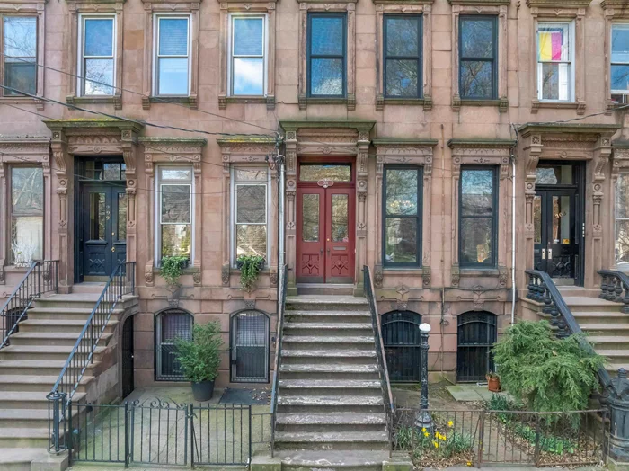 Circa 1875, this classic Italianate style brownstone, spanning 18 feet wide, faces the picturesque Historic Van Vorst Park, boasting a deep 100-foot lot. Upon entry, the double doors lead to a parlor level through an inviting vestibule featuring a mosaic tiled floor with stained glass door panels and transom, opening into a spacious foyer, a large living/dining area, and a well-equipped EIK with top-of-the-line Sub-Zero, Miele & Wolf stainless appliances and 9' soapstone island. Enjoy access to the south-facing 13'x19' deck and garden from the kitchen bay and spiral staircase. The upper two floors showcase a primary bedroom with a wood-burning fireplace nestled in a sun-drenched bay window, complemented by a dressing area with original cabinetry and a marble top basin and three additional bedrooms, with one currently being used as a spectacular library/family room, an office/nursery, laundry, with new w/d, and two fully remodeled, high-end modern baths. The garden level, complete with a full bath, private entrance, and direct yard access, currently serves as a versatile home office and guest suite. Noteworthy features include 11' ceilings, seven etched slate mantels, plaster moldings, original shutters and cornices, intricate parquet floors with mahogany inlay and etched glass pocket doors. The property also boasts a spacious garden, full basement, central air on the lower three floors, custom O'Lampia lighting and newer Marvin windows and doors throughout, adding to its allure and charm.