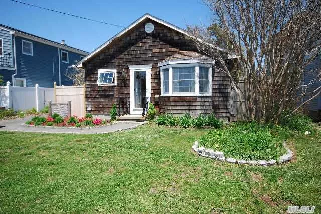 This Charming Village Bungalow Features Many Updates, Living Room Built-Ins, Dining Area Opens To Deck, Wood Floors Thru Out, Commercial Kitchen, Large Master Bedroom And An Over-Sized Garage With Electric And Plumbing Accessed From Rear Street. Come Watch The Boats From The Front Window....