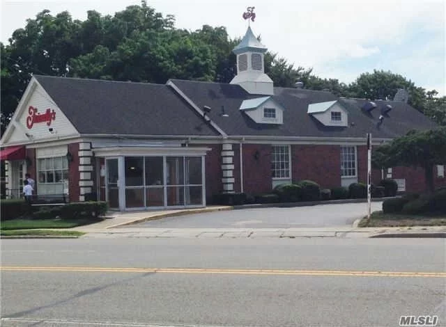 Brick Freestanding Building Located On Busy Street. Two Driveways On Each Side Of Building.