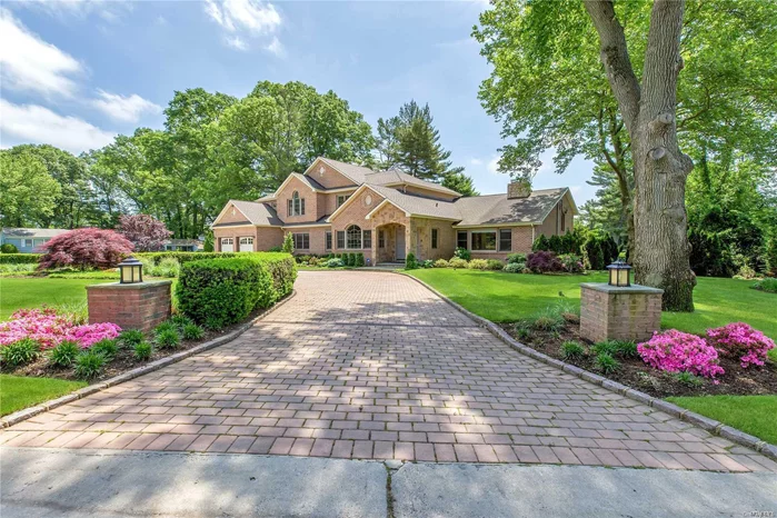 Old Westbury. In a neighborhood of fifteen beautifully-manicured one-acre properties, this charming 1955 home has been thoroughly re-imagined and reborn into a magnificent, multi-level, hi-tech, six-bedroom, four-and-a-half-bath, multi-level brick masterpiece enjoying an acre of sweeping lawns, gorgeous mature shade trees, and breathtaking professional, country-club-like landscaping with patio and pool. With sweeping lawns enfolded by lush shrubbery, the home enjoys a sense of seclusion for its rear entertainment complex. Shaded on one side by towering trees, a sparkling Gunite pool is surrounded by an expansive bluestone patio, ideal for summer entertaining. A shady playground is just steps away, and a large lawn provides ample space for a possible tennis court or putting green if desired. The front yard welcomes guests with a brick and new concrete circular drive accented by lantern pillars. An attached two-car garage with carriage-house doors and a stone arched portico with double entry doors provide an inviting, “Hamptonesque” street presence. Long a popular area for Manhattan’s magnates and luminaries, Old Westbury is just over 30 minutes by railway or highway from Manhattan and major airports.  Conveniently located near parks and museums, it is just a short drive from fine dining, premier shopping, golf, miles of public equestrian trails, polo club, yacht clubs and beaches.  
Combining traditional elements with a touch of contemporary flair, the home’s interior offers a bright and cheerful ambiance with great flow for entertaining.  The entrance foyer, with silvery shimmering ceiling and heated-floor powder room, features LED hi-hats, crown molding, and gleaming hardwood floors that extend throughout much of the home. The sunken, sunny living room boasts an open-beam, vaulted ceiling, fireplace, and a wall of windows. Entered through an archway and continuing a shimmering silver theme in its new grass-cloth wallcovering, the formal dining room features a Palladian window and stunning coffer-like ceiling. Another archway enters the immense eat-in kitchen with radiant-heated stone floors. Interrupted only by nine windows (with new automated Hunter Douglas blinds) and sliding-glass doors, custom granite-topped, hand-glazed cabinetry wraps around this 20-by-28-foot space. It includes a generous breakfast area, a passthrough to the dining room flanked by full-sized refrigerator and freezer, a breakfront, planning center, sink with dishwasher, pro-grade six-burner, griddle, and double-oven gas range with boiserie-enhanced vent hood, and a U-shaped center island with seating area, cabinetry, a bar sink, and one of two under cabinet beverage/wine coolers, a microwave, and a warming drawer. All appliances are stainless steel and high-end. Access to a mudroom and garage and to a rear porch complete this fantastic space. A few steps down from the foyer; is the ground floor great room, a perfect place to enjoy the flat-panel television, with built-in speakers and electronics closet, or relax and contemplate glowing embers in the newly restore sandstone fireplace. Easy-care stone floors and two sets of atrium doors provide easy-care passage from the pool and patio to a full bath and bedroom/dressing room. A few steps down from the great room leads to additional entertainment space with two rooms newly appointed with hi-hats and wood-like porcelain-tile floors.
A few steps up from the foyer, a balcony overlooking the living room accesses three updated bedrooms, the laundry with new appliances, and two designer baths (one with large shower, one with tub/shower, both with twin vanities). A few more steps lead ascend to the master suite level shared by a nursery/playroom, a bedroom (that could serve as a study or walk-in closet), and the palatial master suite. This heavenly retreat enjoys a high-volume ceiling; new hardwood floors; a Palladian window; new automated Hunter Douglas shades; a large, carpeted, custom-fitted cherry, walk-in closet; and a sunny luxury bath with jetted tub, shower with multiple shower heads, twin vanity, and television hidden within the vanity mirror. Offering so many amenities for comfortable living, this lovingly renovated and expanded home, so ideally located, is ready for you to just move in and enjoy luxury “Gold Coast” living.