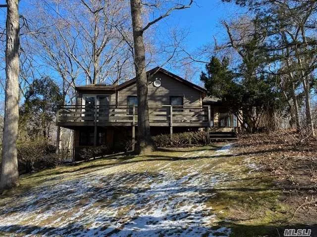 Lovely Hill top setting in a private beach community Scott&rsquo;s Beach, slight winter water view on the rear deck, vaulted ceilings with 9 skylights, stone fireplace, rustic country feel, large windows overlooking the wooded valley give you that tree house feeling. Enjoy your very own private beach, this truly is a rare find.
