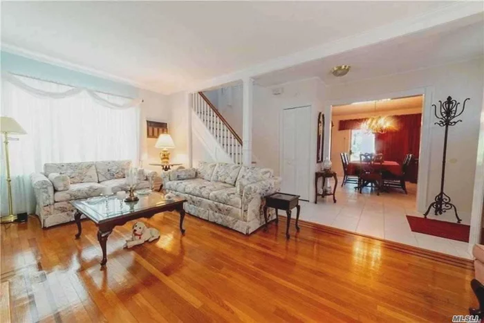 Deceiving Center Hall Colonial on large lot, 36 x 159= 5, 724. Elegant foyer entrance w DR on right and LR on left, den in front of house. Beautiful hardwood floors throughout. Pristine condition and well maintained. EIK w/ granite and SS, appl. 3 season sun room off back of house. Long Yard goes on and on w a lovely gazebo in rear. Master Bedroom is really two rooms together to create MBR and dressing room w sink.  Other bedrooms are very good sizes. MBR & 2nd Br can fit king beds. Pull down attic for storage. Near local and express bus to NYC. House is expandable approx another 1366 sq ft, because of lot size, consult an architect. See Matterport video for a better look!