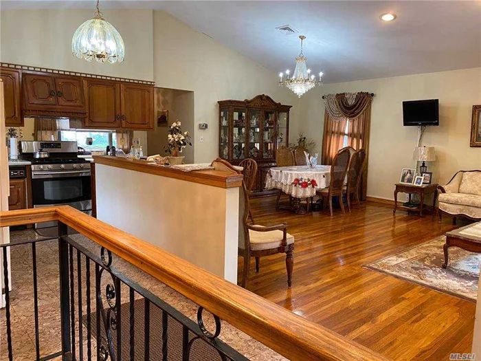 Stunning expanded Brick Ranch with impressive entry/foyer, LR/FDR, EIK, open concept. Cathedral ceiling, hi hats, and wood floors give elegance not found in most Ranch homes. Well maintained, with large den in rear of home. 3 BRs&rsquo; 3 full baths. 1st Floor: LR, FDR, EIk, 3 BRs&rsquo; den, Master bath, main bath.  Bsmt: all tiled, kitchen, LR, Full bath, laundry, garage. closets. Fenced yard, electronic gate in driveway. 2 blocks to grade school, close to bus, LIE, and shopping. See 3-D video tour.