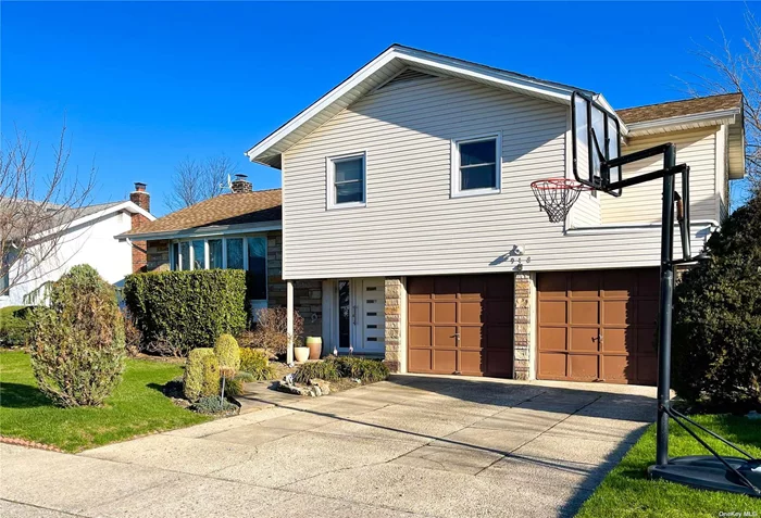 Fully renovated home in the desirable SD 14. The house features contemporary design. Italian-made kitchen, with glass doors in select cabinetry, and a new large Samsung refrigerator. The dining area is illuminated with sunshine from the sliding door that leads to the new backyard deck. All updated Anderson windows, hardwood floors in the main living area and bedrooms. Italian porcelain flooring on the ground floor and finished basement. In the large family room built-in audio system, designer Italian fixtures, Anderson French door with access to the large brick patio. Italian-made doors are installed throughout the home. Master bedroom with a huge walk-in closet/dressing room,  includes a wall-to-wall organization system. Master bath with a therapeutic hot tub, heated floors, and beautiful tiling. Cost-efficient 2-zone gas heating and central air/ductless AC in the family room. A new Samsung Washer/Dryer. 4-zone sprinkler system, and a private backyard. 2-car garage. Low taxes!