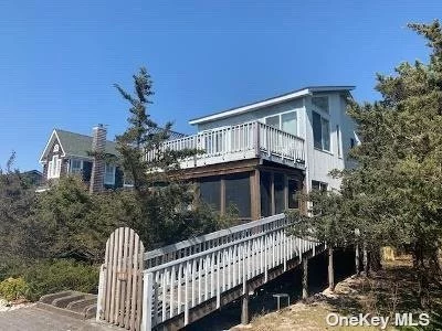 This well maintained summer beach house is centrally located in the quaint community of Lonelyville. The living/dining/ kitchen are open with a propane fireplace in the living room area for off season use. The front screened in porch gives way for an extra area of entertaining. Upper deck off the den area is a place to enjoy the breeze and small view of the ocean off the tree tops. Property is surrounded by trees and scrubs for added privacy.