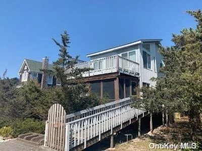 This well maintained summer beach house is centrally located in the quaint community of Lonelyville. The living/dining/ kitchen are open with a propane fireplace in the living room area for off season use. The front screened in porch gives way for an extra area of entertaining. Upper deck off the den area is a place to enjoy the breeze and small view of the ocean off the tree tops. Property is surrounded by trees and scrubs for added privacy.