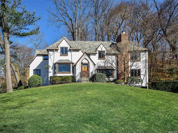 MUST SEE. Stately Tudor, on over half an acre, located in the heart of this sought after Port Washington Estates community. This tranquil home has 4 bedrooms, 3 bathrooms, and 3 fireplaces, one in the living room and one in the primary bedroom. Each of the principal rooms has wonderful scenic views. Close to the town and railroad: Penn station is just 34 minutes away. This property in the Estates includes access to a private sandy beach with docks and mooring rights on Manhasset Bay. A lovingly maintained home that has only had two owners since it was built in 1926. Make this well loved home your own.