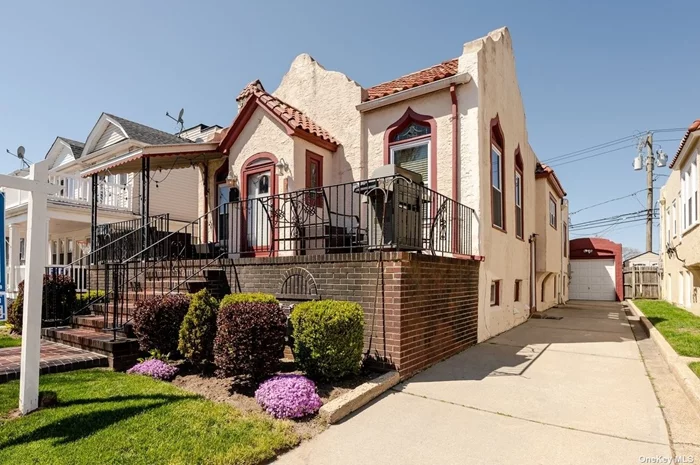 Beachside Westholme Legal Two-Family. This Moorish Revival style stucco house has great curb appeal with clay tile roof, stained glass transom windows, parquet wood floor & South-facing front porch. The entry foyer w/variegated original mosaic tile floor leads to the livingrm with its 13&rsquo; ceilings, wood flrs & woodburning fireplace. Step up to the formal diningrm with wrought iron accent gates & chandelier. Eat-in kitchen. 3 bedrooms & 2 baths. Lower level has a den & utility rm w/washer/dryer that can be accessed from upstairs. The rental unit has ceramic tile floors throughout open kitchen & livingrm, 2 bedrooms & bath. Private driveway & Detached garage. Back patio. Many original details add to the home&rsquo;s charm.