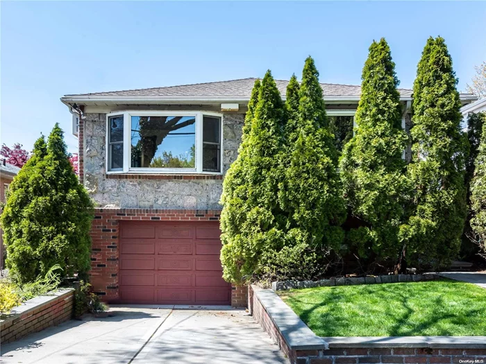 Brick and fieldstone mid-block high ranch with convenient Bayside location close to schools, park, shopping and LIRR. The first floor has a large l-shaped living room and dining with beautiful hardwood floors and 2 bow windows. Eat in kitchen has stainless appliances and access to side of home and rear yard. The primary bedroom has ensuite full bathroom and 2 large cedar closets. There are two additional bedrooms and hall bath on this level. The ground level has a large family room/office with storage closet. Laundry room and add&rsquo;l storage room with access to 1 car attached garage complete this level. Rear yard offers space for outdoor entertainment and garden.