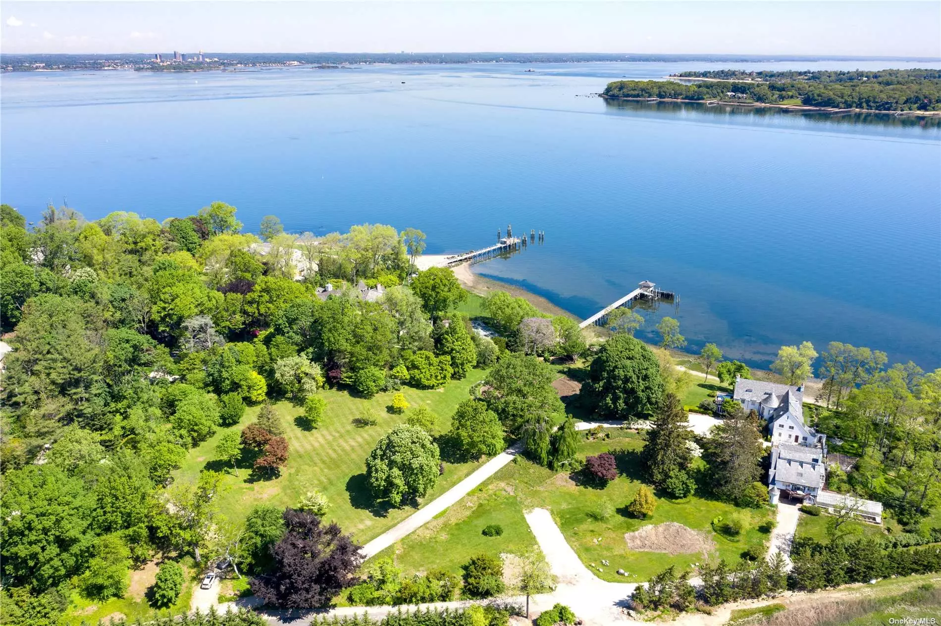 A spectacular park-like property spanning 1.59 acres with stunning unobstructed water views in multiple directions.
