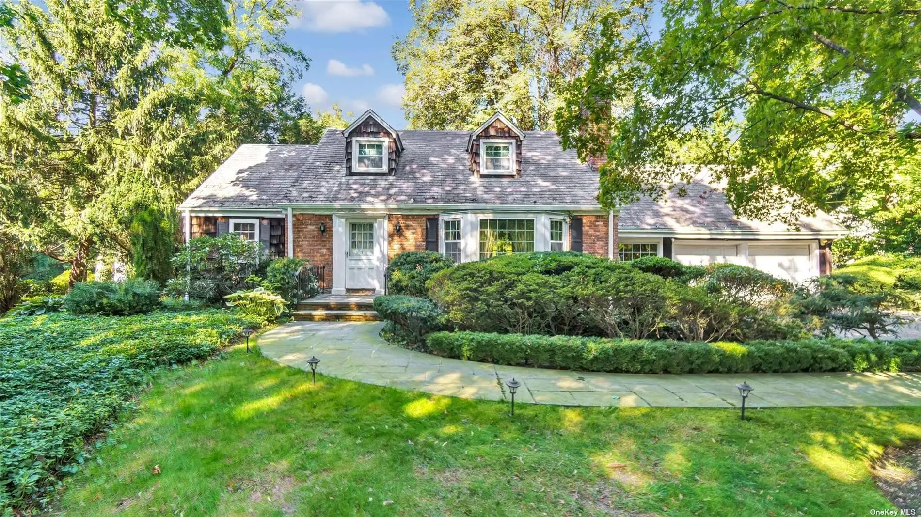 Pride of Homeownership is evident in this charming, expanded ranch in Glen Cove tucked away on 1.3 acres with views of the pristine Nassau Country Club. This well-cared-for home features large rooms, including the option for a first-floor suite, a sun porch, four total bedrooms with three bathrooms, two fireplaces, a slate roof, hardwood floors, and personality at every turn. Close to everything, this house comes with mature landscaping, two car garage, gas heating, Central AC, full partially finished basement, charming bridge & stream, detached one-car garage/storage building and so much more. The perfect canvas to make it your own using the current space or expanding to build the home of your dreams. 1 Raynham Road will not last.