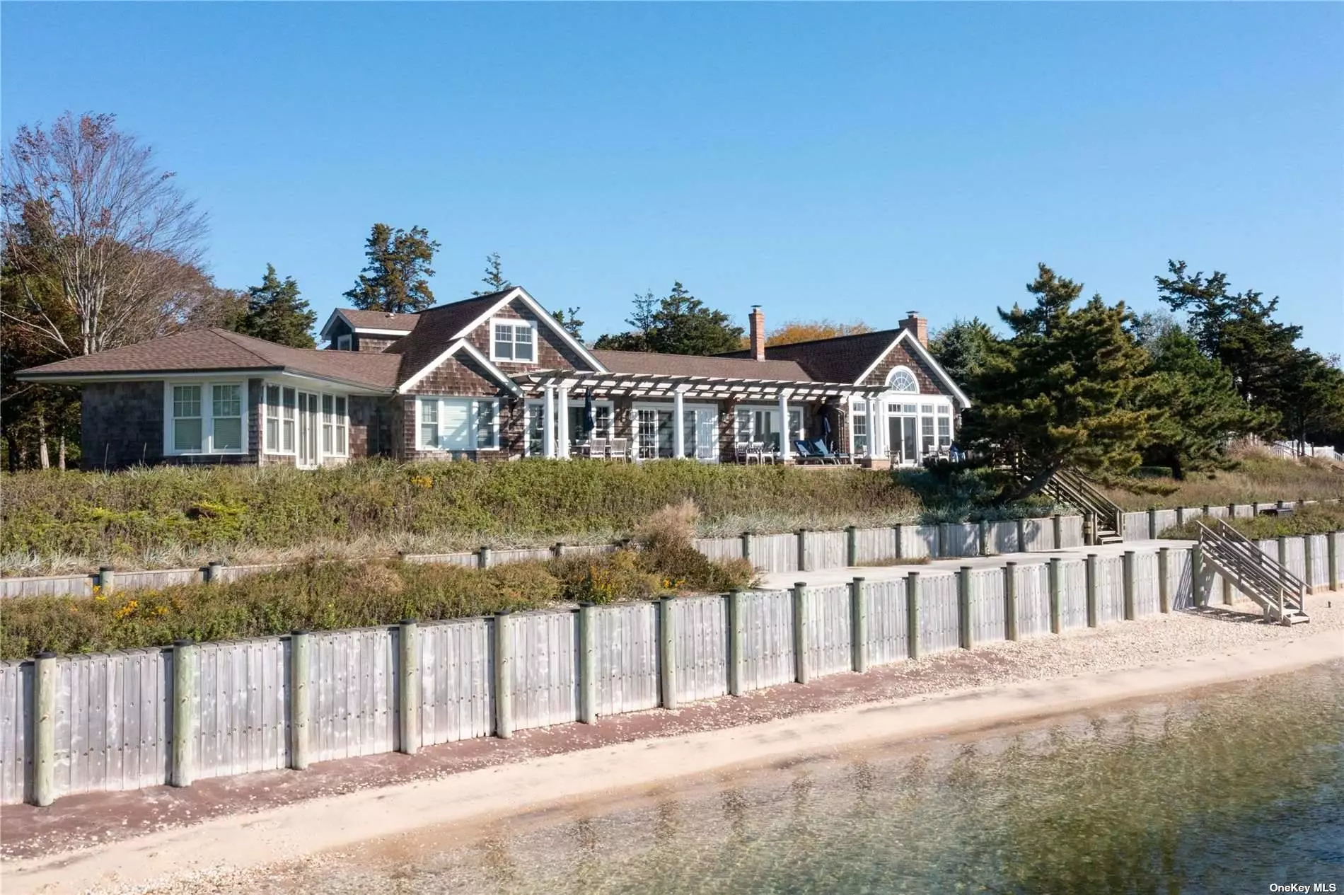 Rare Opportunity To Own a Bayfront Property in prestigious Cedar Beach with a dock. Natural tranquility graces this expansive and secluded home in the heart of Southold. This unique property combines a double-wide bayfront lot with a path across a country lane to your own private dock with one space for a boat, on an inlet leading to the bay. A sophisticated home for the discerning buyer that combines organic textures with hand-crafted finishes. This house exemplifies elegant authenticity boasting a family room with a cathedral ceiling, a slate fireplace, two ensuite primary bedrooms, a living room, and a dining room waterside with sweeping panoramic views. A property like this comes along once in a lifetime.