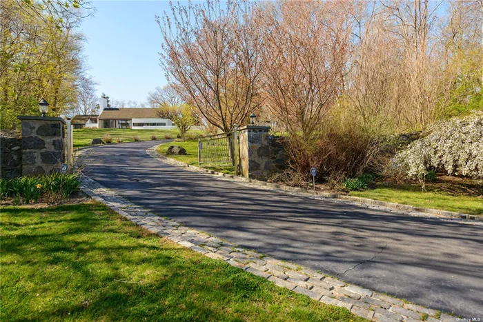 Enjoy the sights and sounds of nature in this private, yet fully expansive, setting! Situated high atop 4.5+ acres of land, within the prestigious Village of Sands Point, this home designed by acclaimed architect George Nemeny, offers a stunning water view of Hempstead bay toward upstate NY and CT. A scenic approach up a Belgium block lined driveway will lead you to a modern California style home with a white stucco exterior and newly replaced Spanish style barrel tile roof. The custom shaped in-ground gunite pool with granite patio is surrounded by a colorful landscape of hydrangeas, Japanese maple trees and natural stone. Within the 5 bedroom-3 bathroom home are high wood timber ceilings, heated flooring, a central AC system, and full height glass sliding doors that provide views and/or direct access to the pool area or surrounding landscape. Panoramic views from the living room and dining area are warmed by the stone fireplace and polished exotic wood flooring.