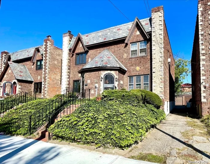 Spacious and Charming 1 Family Tudor Home. Sunken living room has nice high ceilings with exposed beams as well as a wood burning fireplace. Formal dining room leads into the eat-in kitchen with access to the cozy backyard with plenty of space for dining al fresco. The 2nd floor features 2 guest bedrooms, a huge full bathroom as well as a master bedroom with an en suite half bathroom and a wall to wall closet. The basement has a large finished room with a fireplace as well as separate laundry / boiler room with access to the yard. Beautiful hardwood floors and original details throughout the home. Notice: 1 Car Garage. Home is on a quiet block yet close to all including Francis Lewis Blvd, the Clearview expressway and minutes from Bay Terrace.