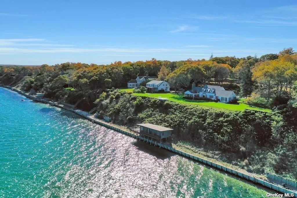 Unique opportunity to curate a legacy residence on North Fork&rsquo;s Nassau Point! Designed for waterfront living, this sprawling estate offers understated elegance with 200 feet of private beach and panoramic views of the Peconic Bay. This property is one-of-a-kind,  as it is adorned with a circa 1960&rsquo;s beach cottage, located above the bulkhead but below the bluff, allowing privacy and easy access to the sand and waves. The main residence&rsquo;s entrance is anchored by a vaulted ceiling, exposed beams, and a grand stone fireplace, providing timeless character. The residence&rsquo;s entryway,  with stone walls, intermixed with mature trees, welcomes you through a rolling driveway, leading your eye to the open water ahead. Timeless opportunity awaits! This is premium waterfront and the sales price solely represents the value of the land alone. Seeing this unique waterfront property is believing!