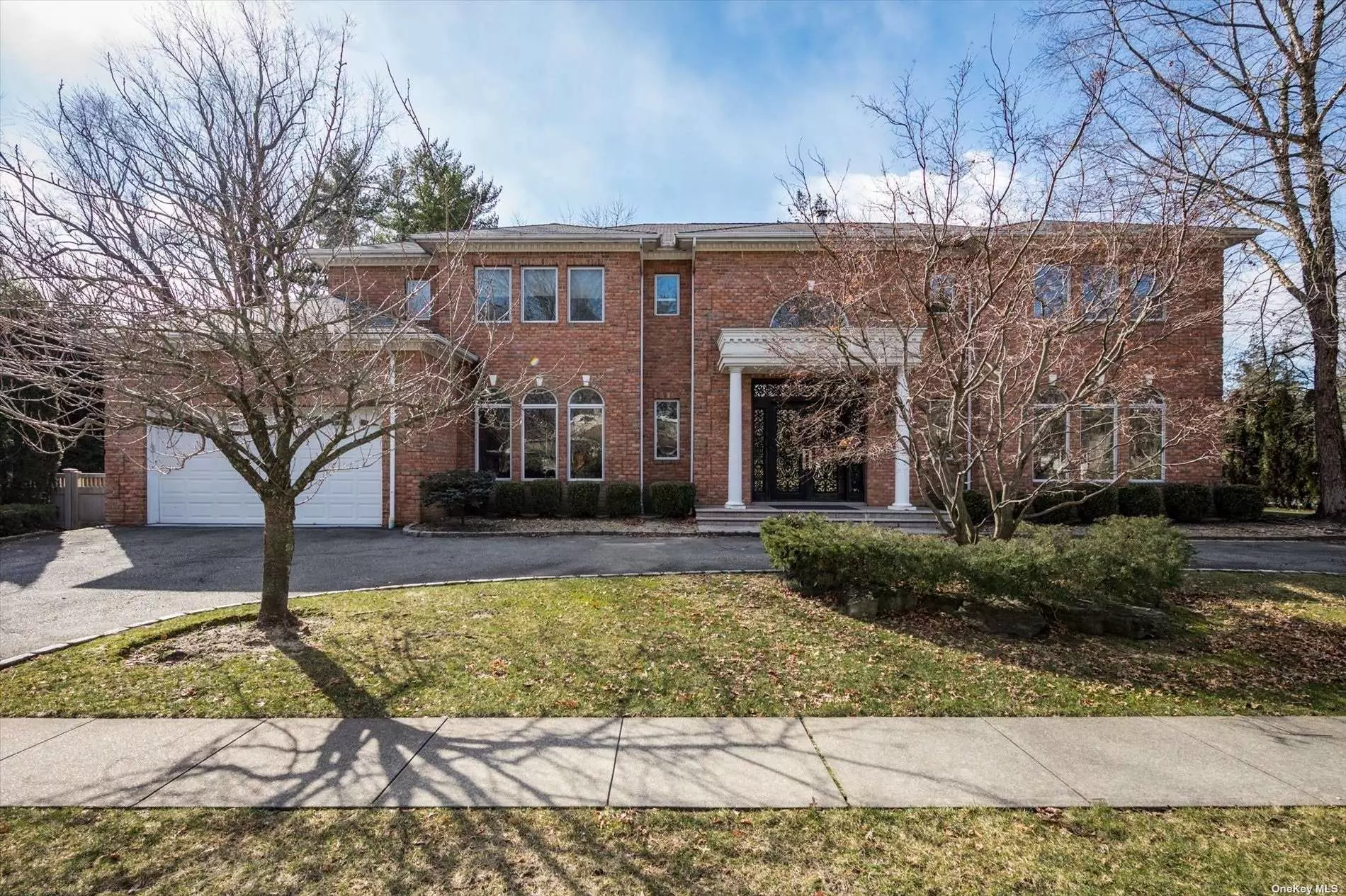 Roslyn Country Club, Stately BRICK Colonial has a Circular Driveway, Two Story Grand Entry with Curved Staircase. Oversized Chef&rsquo;s Gourmet Kitchen with Center Isle, High-End Appliances, Granite Countertops, Breakfast Area with Double sided Fireplace. Gracious Living and Dining Spaces Flooded In Natural Light. First Floor Guest Room or Office with Full Bath and Laundry complete the space. The Second Floor Sitting Area leads into The Primary EnSuite with Walk In closets, Master Bathroom equipped with Jacuzzi and Shower. Three Additional Bedrooms, Two Full Baths Offering Generous Closets. Full Finished Storage Basement With Show Stopping Home Theater. Private Backyard has Patio and Sport Court. Wood Floors, Elegant Moldings & Luxury Touches Throughout. East Williston School District.