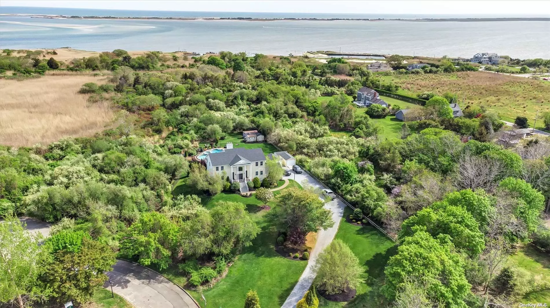 East Moriches Finest! Post Modern 4BRS, 3.5 BTH over 4, 000 sq ft home situated 2.16 acres. Surroundings are priceless and the views are endless of the Moriches Bay! When you first enter - be surprised by the Grand Entry Foyer and Dual Staircases. Details Upon Details - Den, Family Room, w fpl, 1 year young Eat In Kitchen, w/quartz counters, bosh appliances, new roof, and bathroom, 2 Home Offices, Master suite w/ large bath, jacuzzi tub, Walk-In Closets, Full Finished Basement, Central Air, Gorgeous Gunite In Ground Pool, Hot Tub, with professionally landscaping 2 Car Garage - A MUST SEE! Walk to Shops, Water, Restaurants, and a jump away to the Hamptons! Only 1 hour NYC!!West Hampton High School. Great Mother /daughter potential! No Flood Insurance needed!!