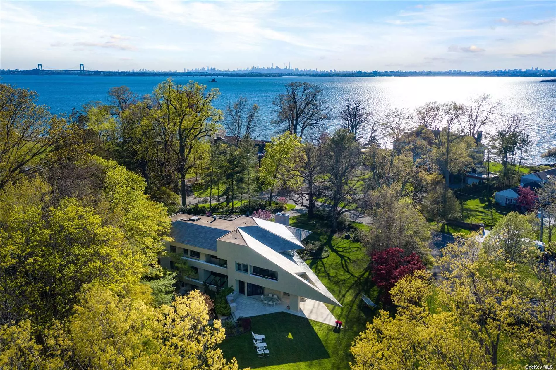 Nestled at the end of a quiet cul-de-sac in Kings Point, 49 Pond Road is a stunning modern, contemporary residence custom built to emphasize exquisite views of the Long Island Sound and Manhattan Skyline. The exterior was designed using timeless materials featuring a cascading blue-slate roof while effortlessly integrating limestone and wood elements. The property boasts 1.3+ acres; the majestic grounds have matured, colorful privacy plantings and sprawling flat lawn space. The yard includes a large stone entertaining patio, half-covered, with a built-in outdoor kitchen and a roomy storage shed. The residence comes with access to a private, sandy beach.