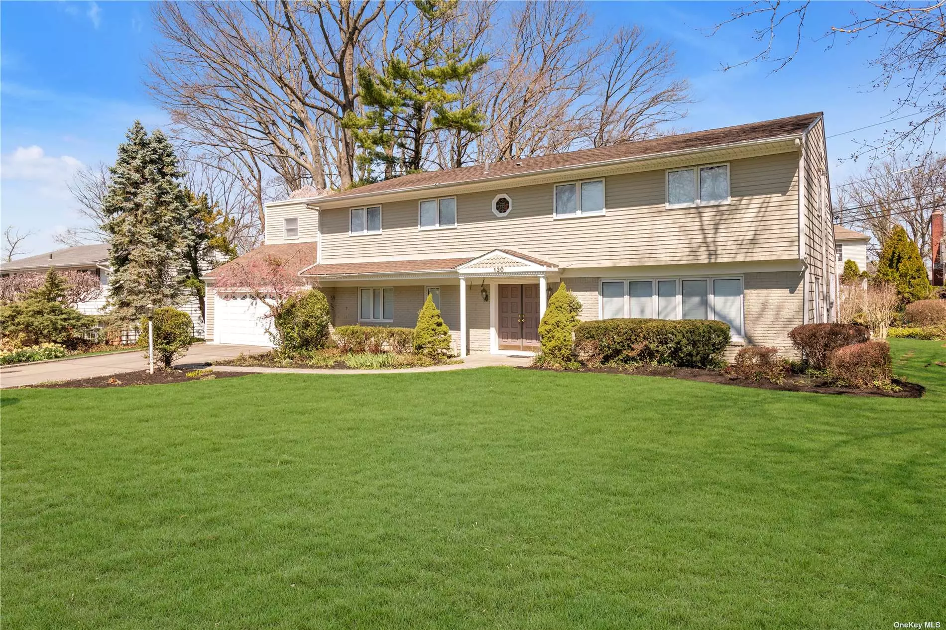 Perfectly situated mid-block Balcony Colonial in sought-after Flower Hill, Manhasset. Spacious entry foyer leads to open floor plan consisting of large den, formal two-story living room and dining room with fireplace. Skylight and wall to wall windows allow for a beautiful bright home with an abundance of natural light. A private bedroom or office, full bath, mud room and laundry complete the first level. The second floor primary bedroom with en suite bath boasts an impressive walk in closet that could double for an en suite office plus three additional generously sized bedrooms that share a bath. Wood floors, partial basement, 2 car attached garage.