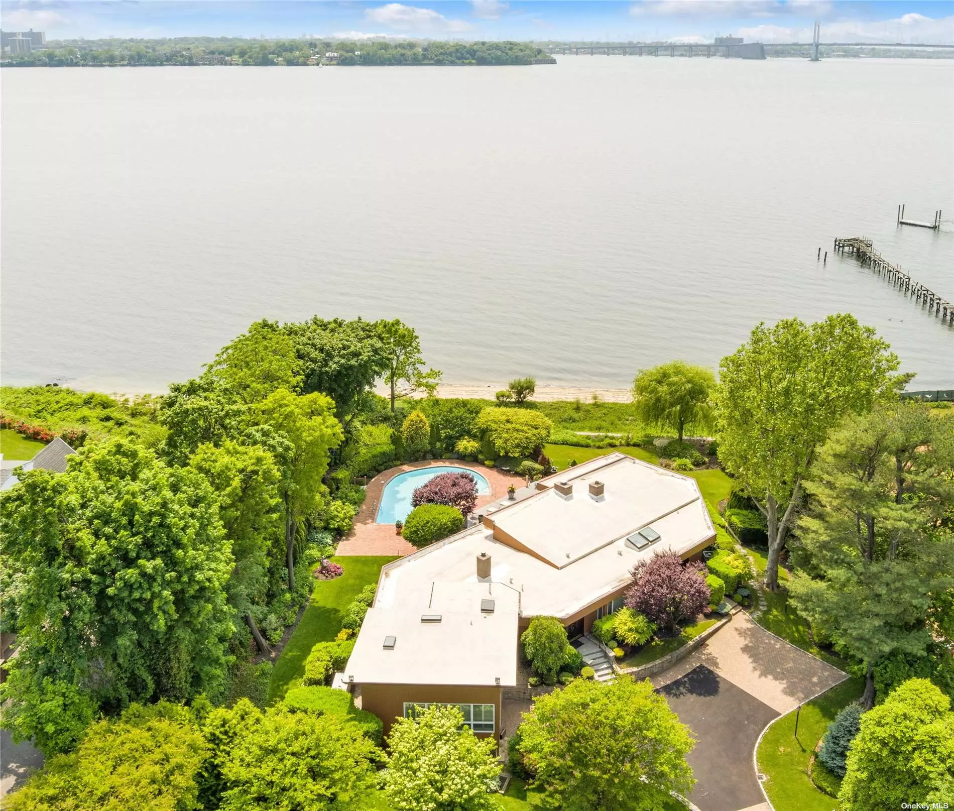 A true waterfront treasure in Great Neck, NY. Village of Kings Point. This stunning direct waterfront property with western views overlooks two bridges and the Manhattan Skyline. The very large 1.32 acre property sits up high with refurbished bulkhead and a beautiful sparkling swimming pool surrounded by patio and deck. Very inviting outdoor entertaining spaces and direct access to the water with private beach for residents only. Enjoy the very best this location has to offer. Inside features spacious open concept rooms, expansive windows and lots of natural light. The Living Room with fireplace, dining room and den all have soaring high ceilings and incredible views. The bridges look like diamond necklaces at night and New York City shines. An eat-in-kitchen, separate Study and Piano Room round out the first floor. Full house generator installed and natural gas. New driveway and belgian block apron. Gorgeous landscaping throughout, colorful gardens, scenic vistas and an absolute gem of a property. Live your dream here.