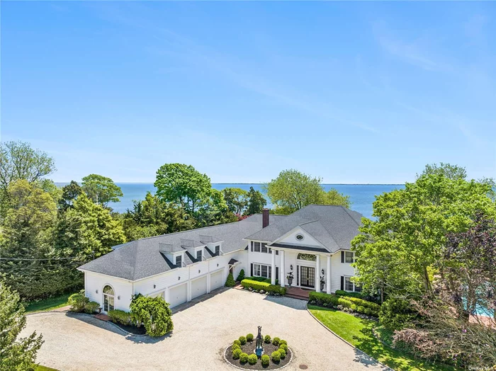 Bay Breeze, a stunning waterfront estate in the Village of Bellport. Sited on a shy 2.5 acres, this remarkable residence is surrounded by mature trees, flowering perennial gardens and unobstructed bay views. The crisp white facade with columned portico and pediment above welcomes you to a spacious home, with every amenity. Currently undergoing a refresh with freshly painted walls and trim across three levels, new lighting and new roof on the pool house! On the main level, water and garden views are enjoyed from nearly every room. A handsome study, spacious living and dining rooms, lounge with bar and an oversized kitchen are found here. Level two, is dedicated to rest and relaxation among 5 bedrooms and baths, office, bonus rooms and a separate wing dedicated to fitness and refreshment bar. The third floor is home to an expansive recreation area and powder room. This exquisite property includes pool house, 20x50 heated Gunite pool and spa, and Har-Tru tennis court. The 248&rsquo; of marine wall runs along the south property boundary and includes a dock perfect for watercraft and water sport. Not to be forgotten, is the 3 tee wedge range with elevated green protected by sand bunkers with its charming caddy shack, perfect for the weekend warrior or aspiring tour pro. The special quality of this resplendent estate is found in the elegance of its luxurious residence in a beautiful waterfront setting with amenities tailored for today&rsquo;s exceptional living.