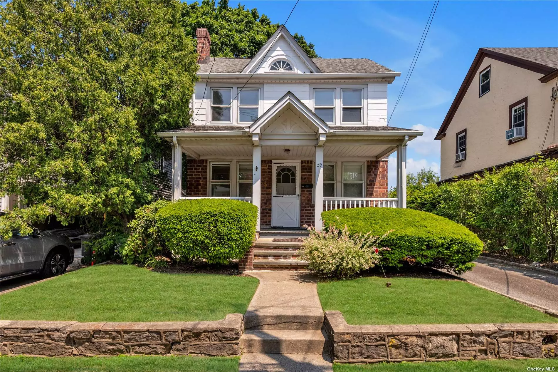 Charming Front Porch Colonial with living room with woodburning fireplace, formal dining room, eat-in kitchen. 3 bedrooms, full bath. Full basement with washer/dryer. Walk-up attic. 2-car garage. Less than 1 mile from LIRR.