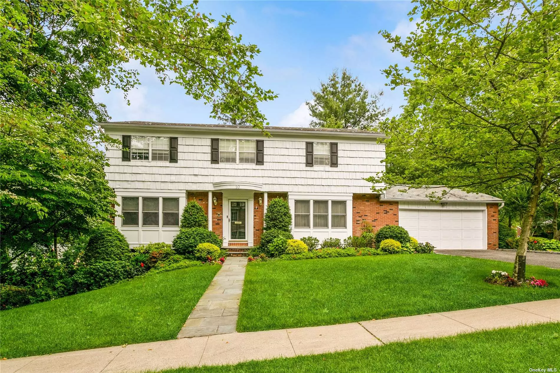 Stately Center Hall Colonial perfectly located on a quiet corner location in the Village of Russell Gardens. The entry foyer leads to a large Living Room, spacious Den, Eat in Kitchen, Formal Dining Room and Powder Room. The second floor boasts a primary ensuite with an oversized walk-in closet plus 3 additional family Bedrooms and 2 full Bathrooms. A full finished walkout basement with gym, play area and plenty of storage opens to a deck overlooking a serene backyard with beauitul landscaping and flowers. Russell Gardens has its own private pool and 3 clay tennis courts.  This home is conveniently located to town, LIRR, public transportation, shops & highways.