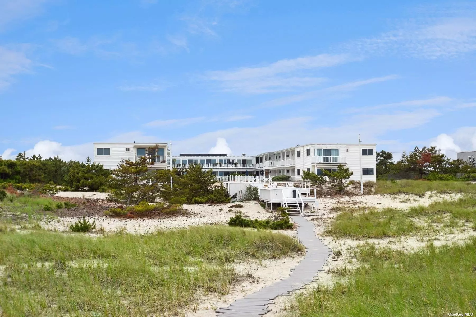 Oceanfront effortless beach living at the sought after La Coquille complex, located directly on the white sandy beaches of Dune Road and a just short stroll to Main Street for village shops and restaurants. This studio/1 bath unit with open kitchen and living spaces is a perfect summer retreat for no fuss easy days on the beach. It is a sunny 1st floor unit with a wall of windows and sliders to access a private balcony or walk right out to the heated pool and ocean. The doorman attended building with concierge services is smoke and pet free, and offers separate owner&rsquo;s lockers and bike storage, laundry in the building, as well as owner reserved and guest parking.