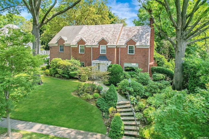 Exquisite center hall brick colonial on a prime block of Jamaica Estates, situated on a combined lot of 101x150, totaling 15, 161 square feet. As you step inside, you are greeted by a warm and inviting living room featuring a marble fireplace. The stunning family room with cathedral ceilings and skylights offers abundant natural light. The remarkable kitchen boasts top-of-the-line appliances, two sinks, two dishwashers, two ovens, a large island, granite countertops, and an adjacent office. A large formal dining, overlooking the magnificent scenery, adds elegance for formal occasions. On the first floor, there is also a guest bedroom and a full bathroom.       The second floor features a primary suite, with a full marble bathroom and a loft. There are four additional bedrooms with two full bathrooms, one ensuite. The full basement includes a spacious family room, full bathroom, maids quarters, large laundry room, and a 2-car attached garage. However, it is the backyard that truly captivates the senses. With access from both the kitchen and the family room, step outside into a haven of tranquility and beauty. The magnificent, professionally landscaped grounds are a true masterpiece, offering a serene retreat for outdoor enjoyment., Additional information: Interior Features:Guest Quarters, Lr/Dr