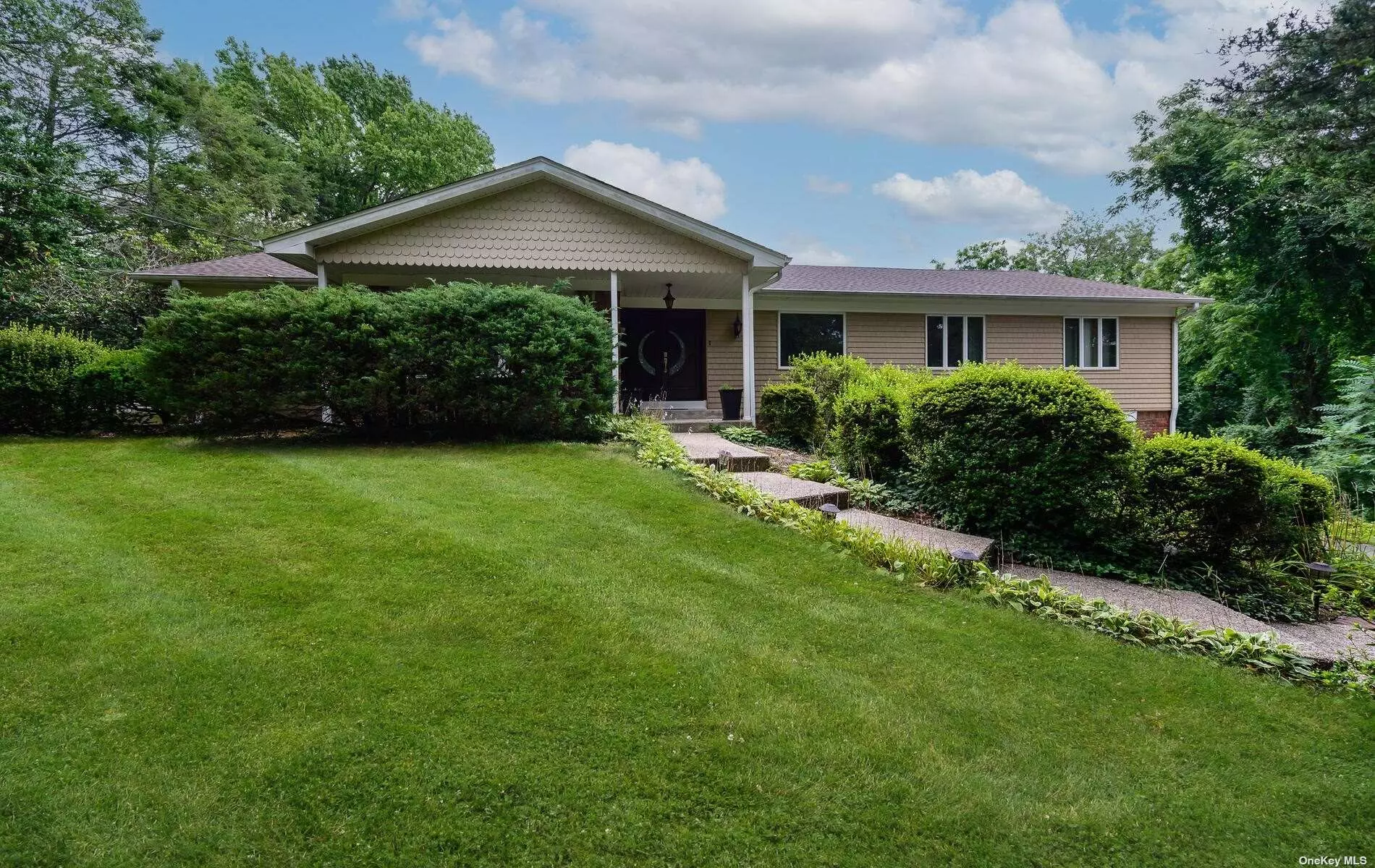 This luxury Ranch home on Long Island&rsquo;s Gold Coast is truly one-of-a-kind, boasting a fully renovated open floor plan and impressive features across its 2, 800+ square feet. The property spans an acre, combining Nassau and Suffolk areas to offer generous outdoor space with mature plantings. Inside, the home is adorned with exquisite custom details, including porcelain flooring, a three-sided fireplace, high ceilings, and oversized windows, creating an elegant and inviting ambiance with abundant natural light. The foyer entrance provides immediate views of the expansive landscaped gardens through the large living room windows. The open floor plan seamlessly connects the dining room, foyer, and state-of-the-art kitchen, complete with top-of-the-line appliances ideal for aspiring or professional chefs. The master suite prioritizes comfort and luxury, featuring a custom walk-in closet for two individuals and a well-appointed bathroom with a custom shower and Jacuzzi. Moreover, the above-ground lower level offers versatility, serving as a work-from-home space with a private entrance or guest accommodation. It includes three rooms, each equipped with a split AC system for ultimate comfort. This level also houses a full bathroom, laundry facilities, and utility amenities for added convenience. Overall, this exceptional Ranch home on the Gold Coast of Long Island combines luxury, comfort, and functionality, making it highly appealing to those seeking a premium living experience.